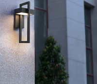 Rectangular black outdoor LED wall light on a stone facade