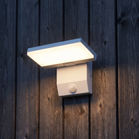 White outdoor LED wall light with motion sensor installed on dark timber