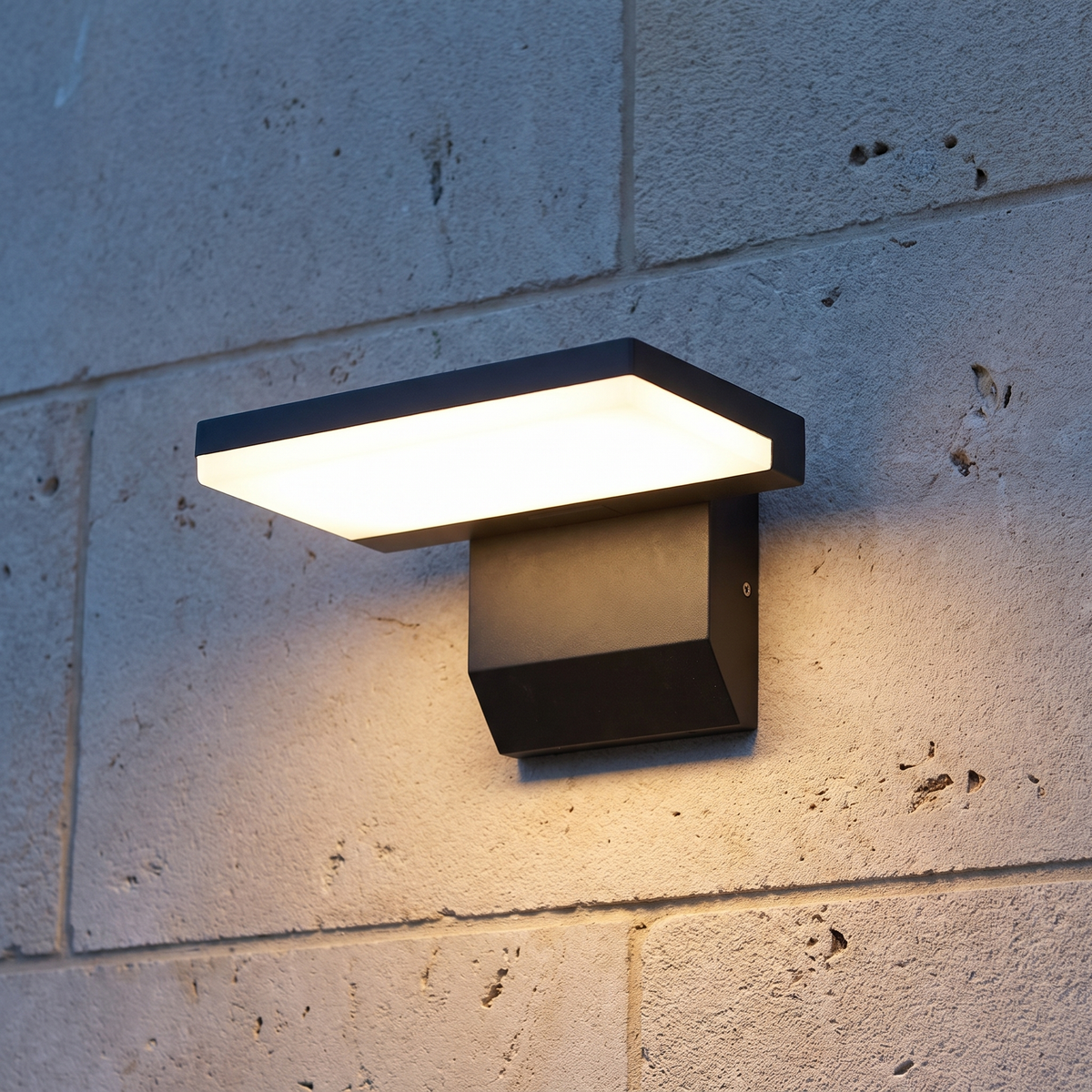Black outdoor LED wall light without sensor installed on limestone