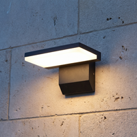 Black outdoor LED wall light without sensor installed on limestone