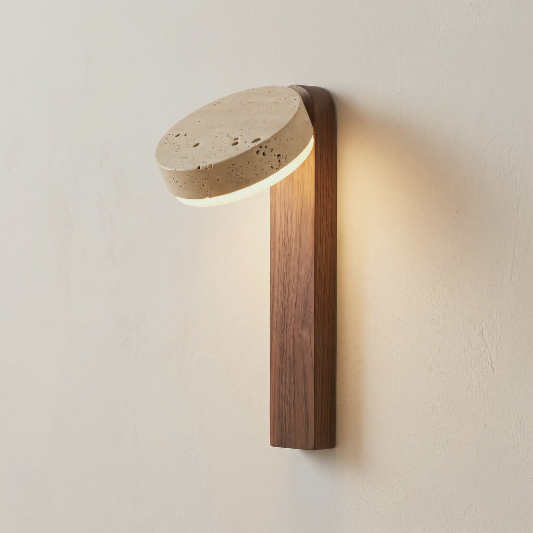 A hand turning the travertine stone head, the warm light moving on the wall